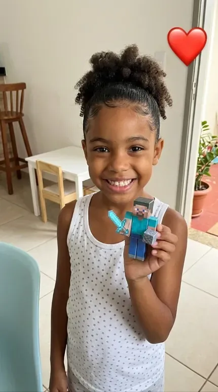 Niña sonriendo con su personaje de papel 3D armado